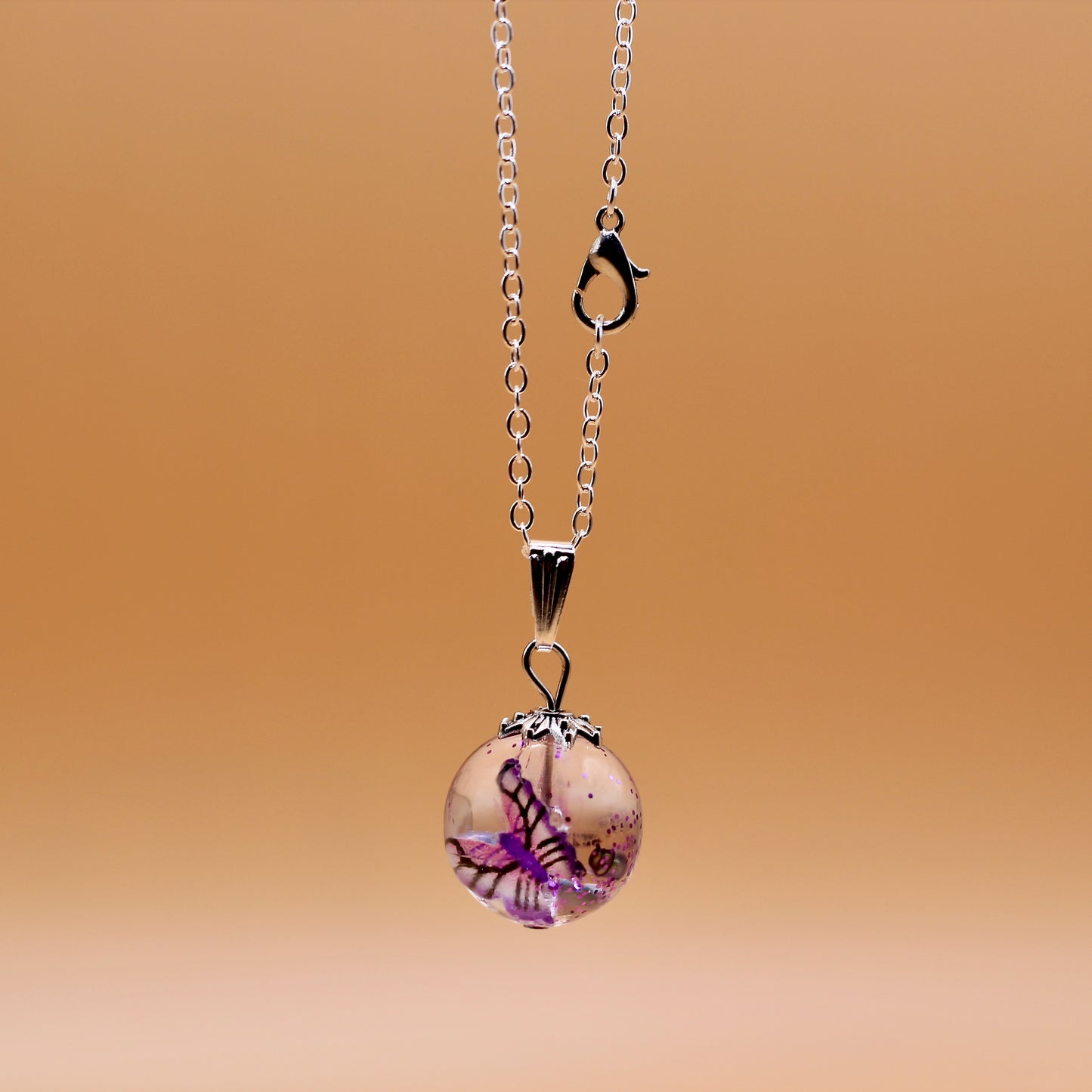 Ketting met bol en roze vlinder