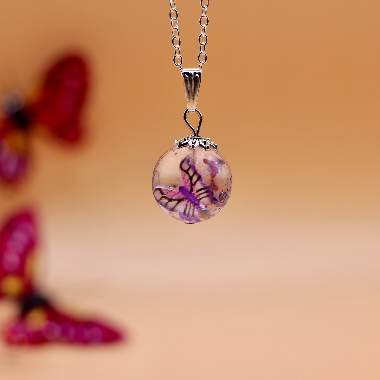 Ketting met bol en roze vlinder
